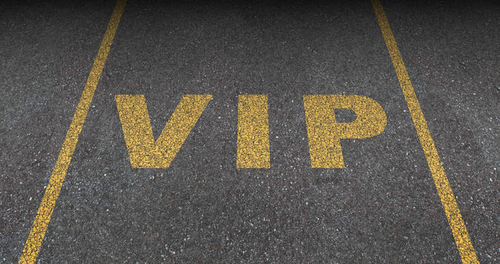 VIP service symbol with a first class reserved parking space for with a sign painted on asphalt as a symbol of exclusive hospitality with the royal treatment with a blank area for text.
